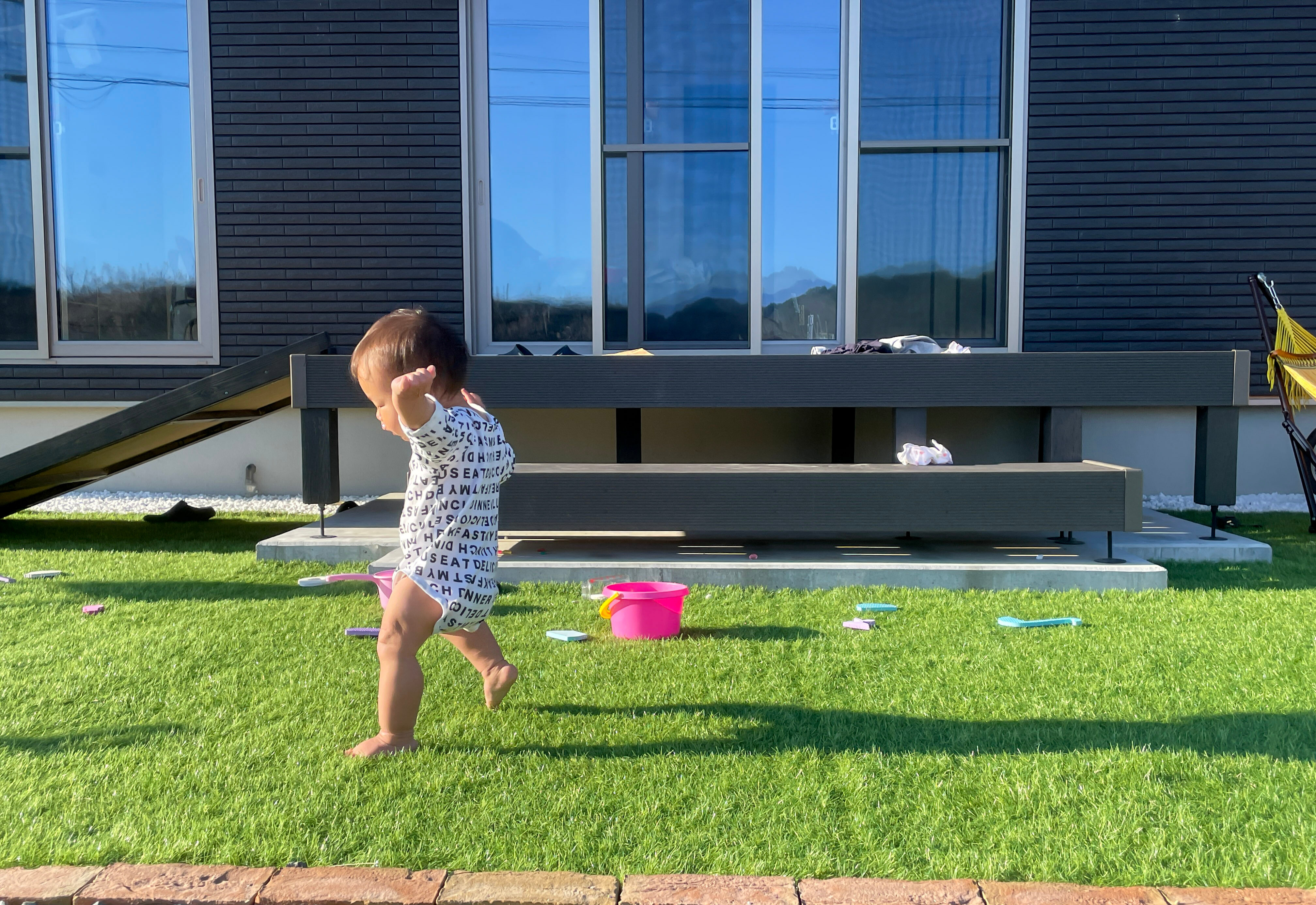 家の庭で遊ぶ男の子の赤ちゃん